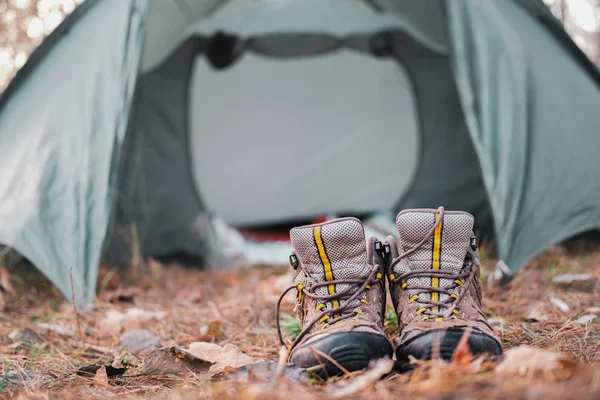 Descanso activo al aire libre: un par de zapatos de senderismo en un camping . — Foto de Stock