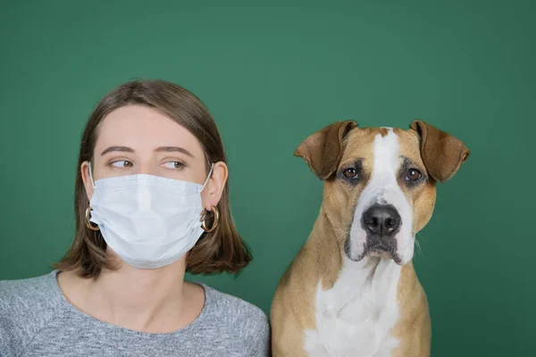 Portret van een vrouw die haar neus snuit in een servet en naar haar hond kijkt. — Stockfoto