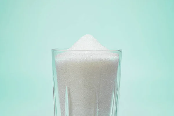 A glass full of sugar in isolated background. — Stock Photo, Image