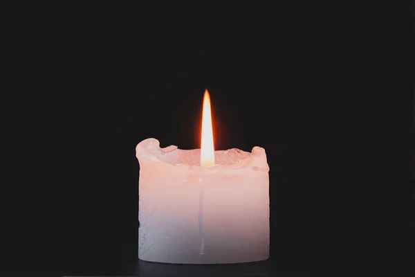 Крупный план горящей свечи на черном фоне . — стоковое фото