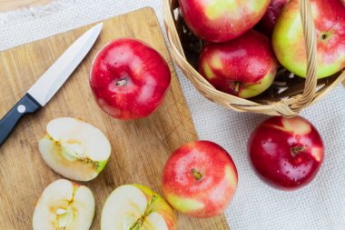 Kırsal ahşap masada olgun sulu elmaların üst görüntüsü. Ev yapımı organik elma ve bıçak, yukarıdan atılmış.
