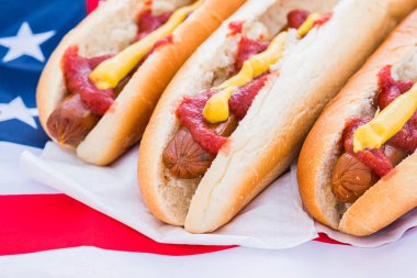 Ketçaplı ve hardallı sosisli sandviç, yakın çekim. Amerikan fast food konsepti: Sosisli sandviç servis edildi ve yemeye hazır.