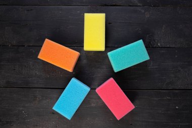 Sponges form a pentagon star shape, top view. Five pieces of dishcloth on dark background, shot from above clipart