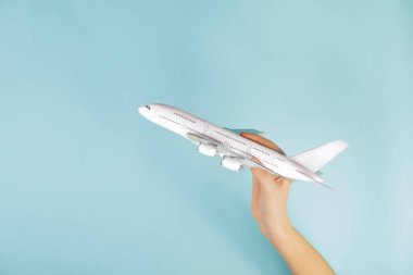 Mavi arka planda insan eliyle yapılmış jet uçağı modeli. Bir uçağın havalanıp gökyüzüne uçması konsepti