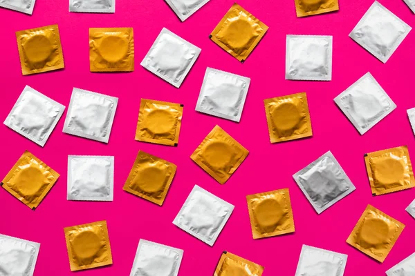 粉色背景的避孕套 顶视图 大量避孕套 从以上安全性行为和避孕概念拍摄 — 图库照片