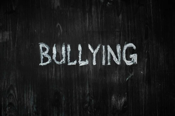Palavra Bullying Escrita Mão Sobre Fundo Madeira Preta Signo Conceito — Fotografia de Stock