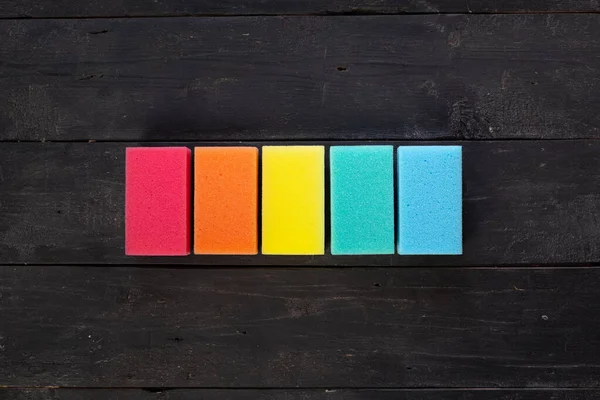 Koyu Arkaplanda Farklı Renkte Süngerler Üst Görünüm Beş Parça Bulaşık — Stok fotoğraf