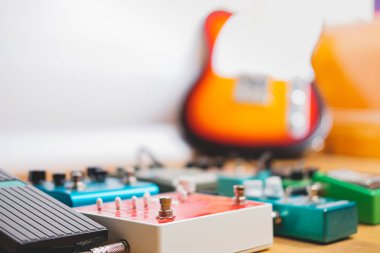 Kayıt stüdyosunun zemininde gitar pedalları, arka planda elektro gitar. Ahşap zeminde genel gitar efektleri. Gitar kaydı, rock müzik yaratma kavramı