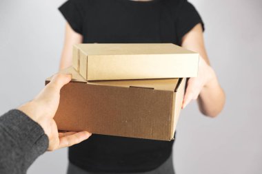 Kutuları mal alarak ya da vererek. Teslimat, posta servisi veya postacı konsepti: elden ele verme