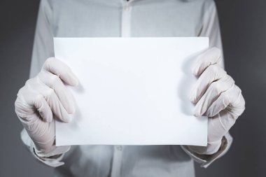 Eldiven takan boş bir kağıt parçası. Metin yerleştirme, beyaz yaka konsepti, bilim veya tıbbi iş teklifi, fırsat, yeni iş veya diğer işaretler için boşluk kopyala