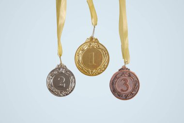 Tecrit edilmiş arka planda birinci, ikinci ve üçüncü ödül madalyaları. Spor, rekabet ve ödül kazanma kavramı