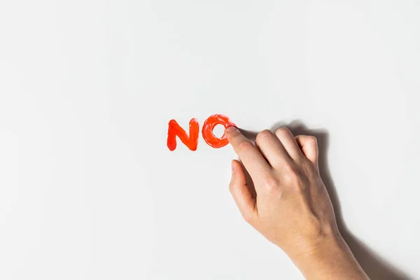 Mulher dedo desenha uma palavra "Não" com tinta vermelha em um fundo branco . — Fotografia de Stock