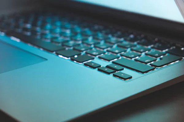 Vue rapprochée du clavier rétroéclairé de l'ordinateur portable et de la lumière bleue de l'écran . — Photo