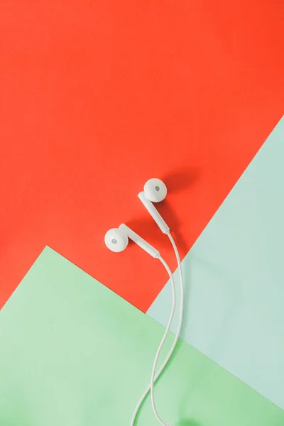 Ζευγάρι ακουστικά στο αυτί σε φωτεινό πολύχρωμο φόντο. — Φωτογραφία Αρχείου