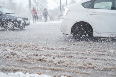 Kar fırtınasında şehir trafiği, hareket bulanıklığı. Arabalar kötü hava koşullarında kirli, temiz yollarda yol güvenliği kavramından geçer.