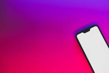 Neon arka planda modern jenerik akıllı telefon. Canlı mavi ve kırmızı arkaplanlı beyaz ekranlı cep telefonu