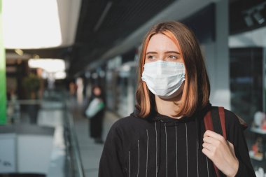 Alışveriş merkezinde koruyucu maskeli bir kadın. Coronavirus, Covid-19 yayılma önleme konsepti, bir vatandaşın sorumlu sosyal davranışı