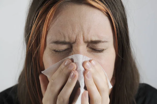 Sneezing, coughing or blowing nose in a single use paper towl. Concept of catching cold, virus or infection and not spreading it