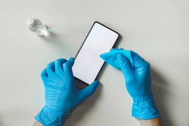 Cep telefonunu dezenfektan ve bezle temizliyorum. Kişisel hijyen kavramı, virüse karşı koruma, covid-19 yayılma farkındalığı