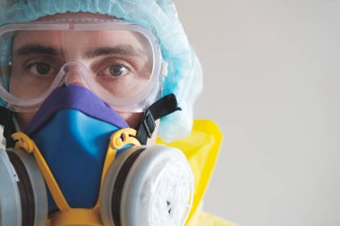 Koruyucu maskeli, gözlüklü ve kafa korumalı bir adam. Tıbbi personel, bilim adamı veya MD iş donanımı, covid-19 konsepti, virüs, salgın hastalık ve aşı geliştirme