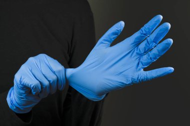 Mavi lastik eldiven takıyorum. Enfeksiyon ya da virüse karşı koruyucu el teçhizatı takmak. Covid-19, laboratuvar ya da bilimsel laboratuvar konsepti
