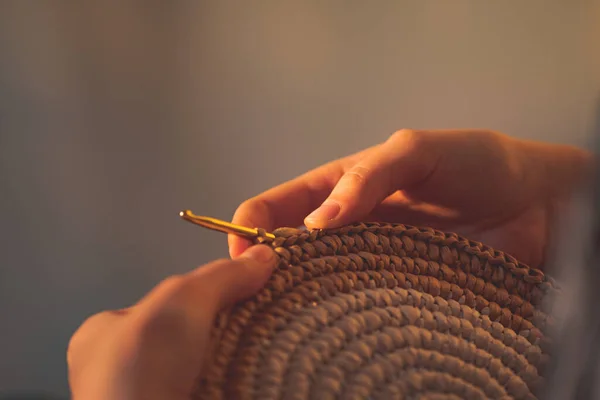 女性の手でラウンドラフィアかぎ針編みパンノ 工芸品 趣味のコンセプト 壁のハンギングとかぎ針編みのフックを作る — ストック写真
