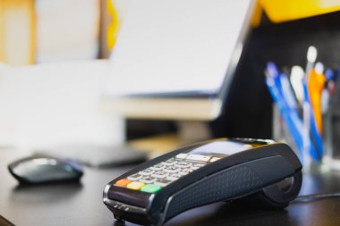 Ödeme terminali bir masada, yakın çekim görüntüsü. Bir perakende mağazasının kasiyerlik masasında POS terminali, yerel iş konsepti