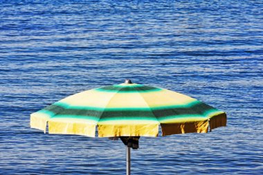 Deniz kenarında renkli şemsiye