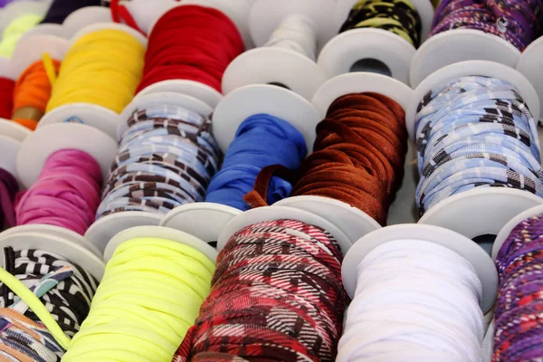 Spools of colored cloth in selective focus