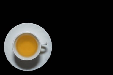 Yasemin çay bardağı doğru boşaltmak ile siyah arka plan