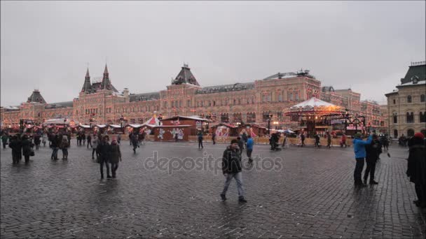 Moskva, Ryssland - 28 januari 2017: Kreml: människor njuta av livet i Röda torget i en molnig vinterdag med landskap av staten varuhuset Gum omfattas av julbelysning — Stockvideo