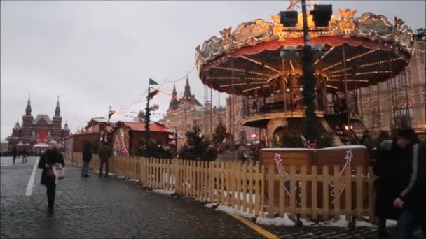 Moscow, Rusland - 28 januari 2017: Kremlin: mensen genieten van het leven op het Rode plein, kinderen gaan in de carrousel en plezier op een bewolkte dag — Stockvideo