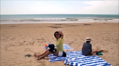 Esmer kadın selfie tropikal plaj Hainan Adası - Çin oturtunuz.