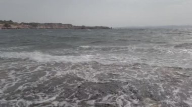 Kıyı şeridinin panoramik manzarası ve İtalya 'nın Sardunya bölgesindeki Saint Peter Adası' ndaki kayalıkları ile dalgalar kayalık kıyılarda kopuyor.