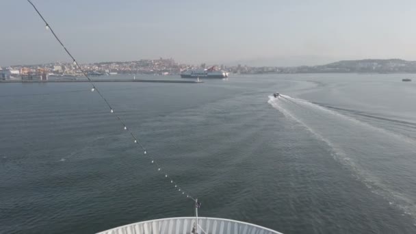 意大利卡利亚里 Cagliari 2019年9月20日 渡船驶向撒丁岛的卡利亚里港 Cagliari Port 正在跟随领航员快艇驶向正确的方向 港口入口有防波堤和大灯 远离地雷尼亚轮渡和城市天际线 — 图库视频影像