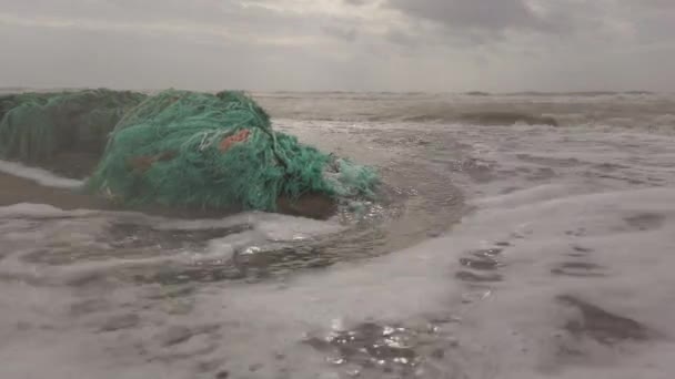 自然は 環境汚染に苦しむ海から噴出したネットのプラスチック廃棄物の残骸と人間の損傷を強制的に回復させます — ストック動画