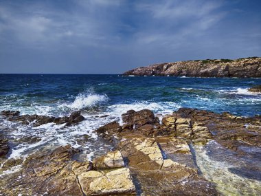 İnanılmaz deniz manzarası ile mavi dalgalı deniz kayalık körfeze çarpıyor. 