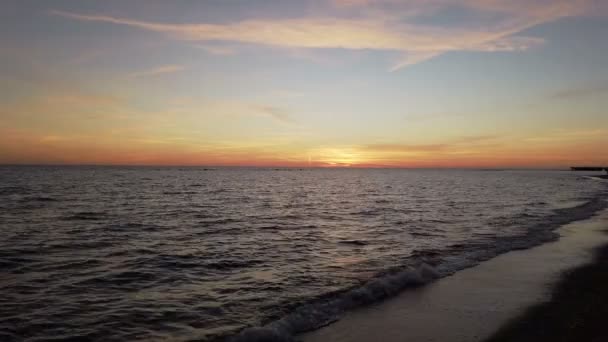 オレンジと青い空と美しい海の夕日を水の端と波でリラックスしてください — ストック動画