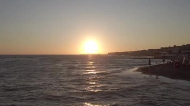 Roma, İtalya - 19 Eylül 2019: Roma kıyılarında gün batımını rahatlatmak, ufka yakınlaşmak ve sahile ve şehir siluetine yansımak, insanların güzel ve rahatlatıcı bir anın tadını çıkarmak.