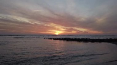 Sahilde muhteşem bir gün batımı. Güzel güneş ışığı ve dramatik bulutlu gökyüzü ile ufka doğru yakınlaş.