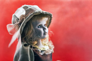 Özenle seçilmiş porselen bebek portresi sarı kıvırcık saçlı ve mavi gözlü bir başlık giyer. 