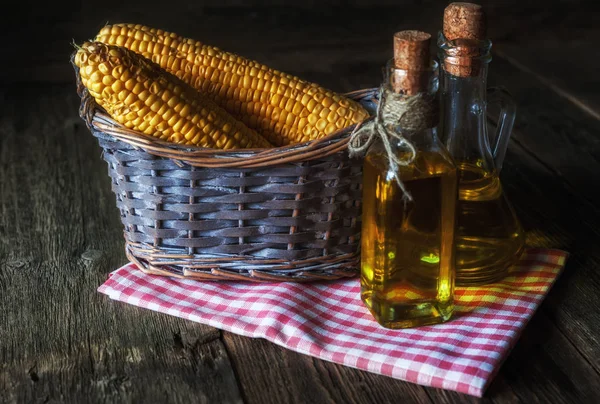 Ear of corn and bottles with corn oil