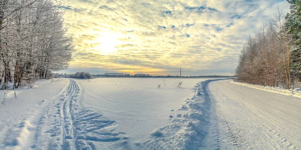 Winter landscape - the sun shines through the clouds on a deserted snowy landscape