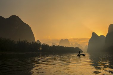 Guilin China.Guilin Çin peyzaj Li nehrinde karabatak ile balıkçı.