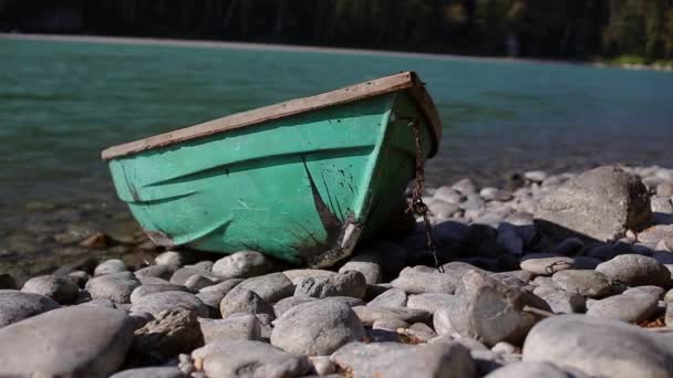 Παλιό ξύλινο σκάφος πράσινο είναι στην όχθη ενός ποταμού στο βουνό — Αρχείο Βίντεο