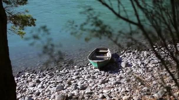 Oude houten groene boot is aan de oever van een rivier berg — Stockvideo