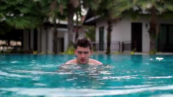 Um jovem na piscina do hotel nos dedos conta até 5 — Vídeo de Stock