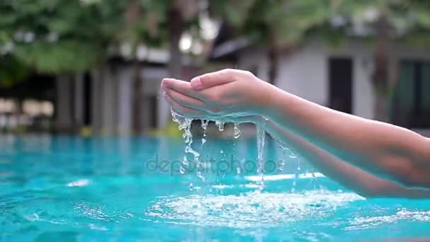 En la palma de la mano los hombres reclutaron agua y se vertió en la piscina del hotel — Vídeos de Stock