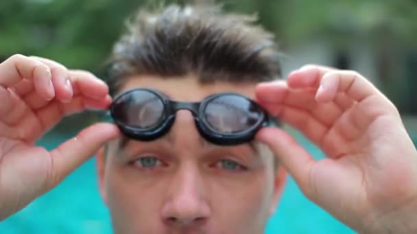 Jeune homme met des lunettes et des plongées dans la piscine — Video