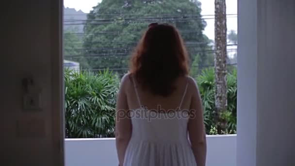 Dívka chodí z hotelového pokoje a vypadá na déšť — Stock video